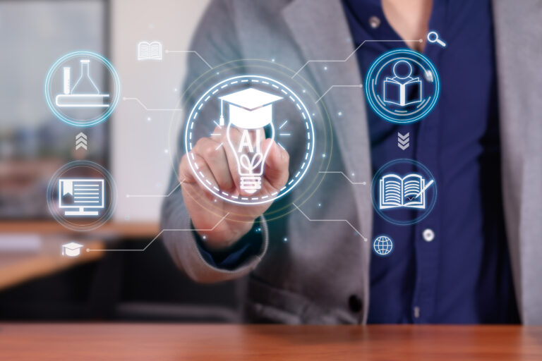 A person in a blazer is pressing a virtual graduation cap icon on a digital interface. Surrounding icons include a book, computer, and test tube, symbolizing education and technology. A blurred office background is visible.